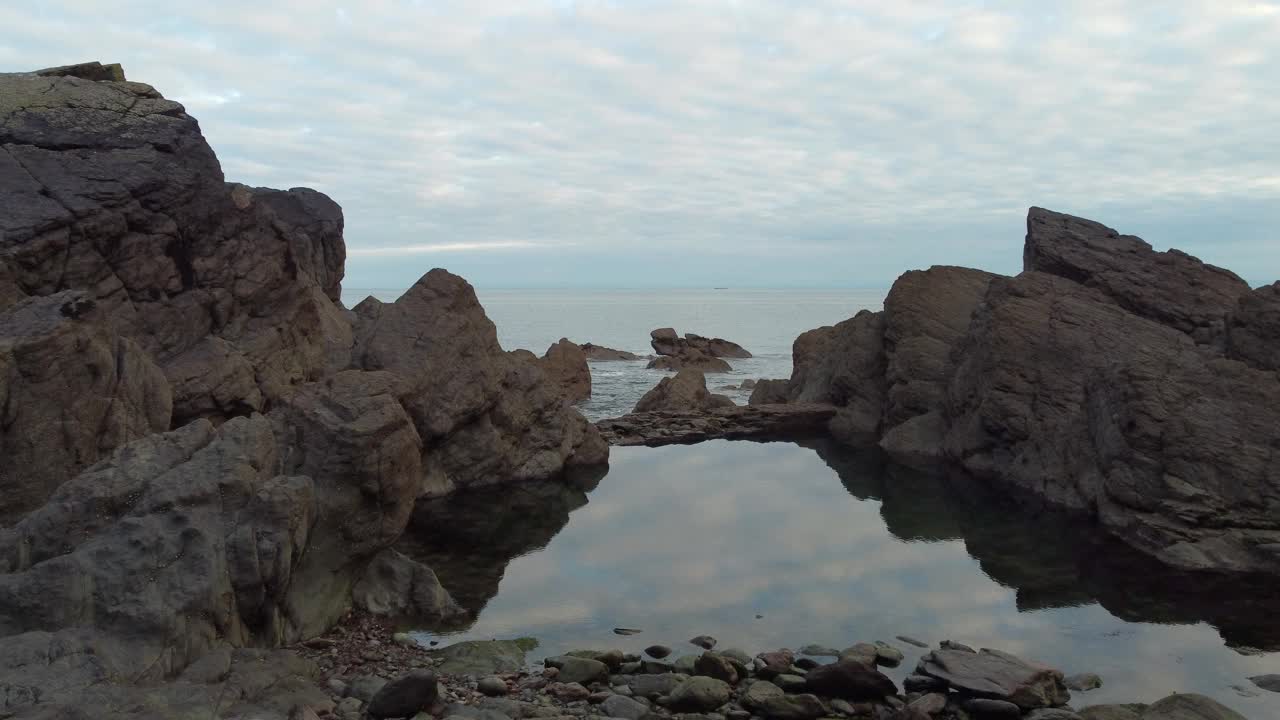 海洋维多利亚岩池航拍无人机镜头，潮汐来到伍迪湾德文郡4K视频素材