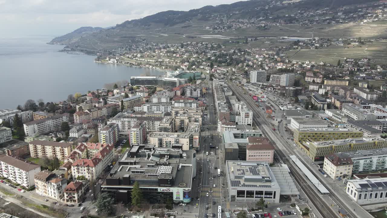 在瑞士沃韦(Vevey)以4K画质鸟瞰海边的道路、密集的建筑和山脉视频素材