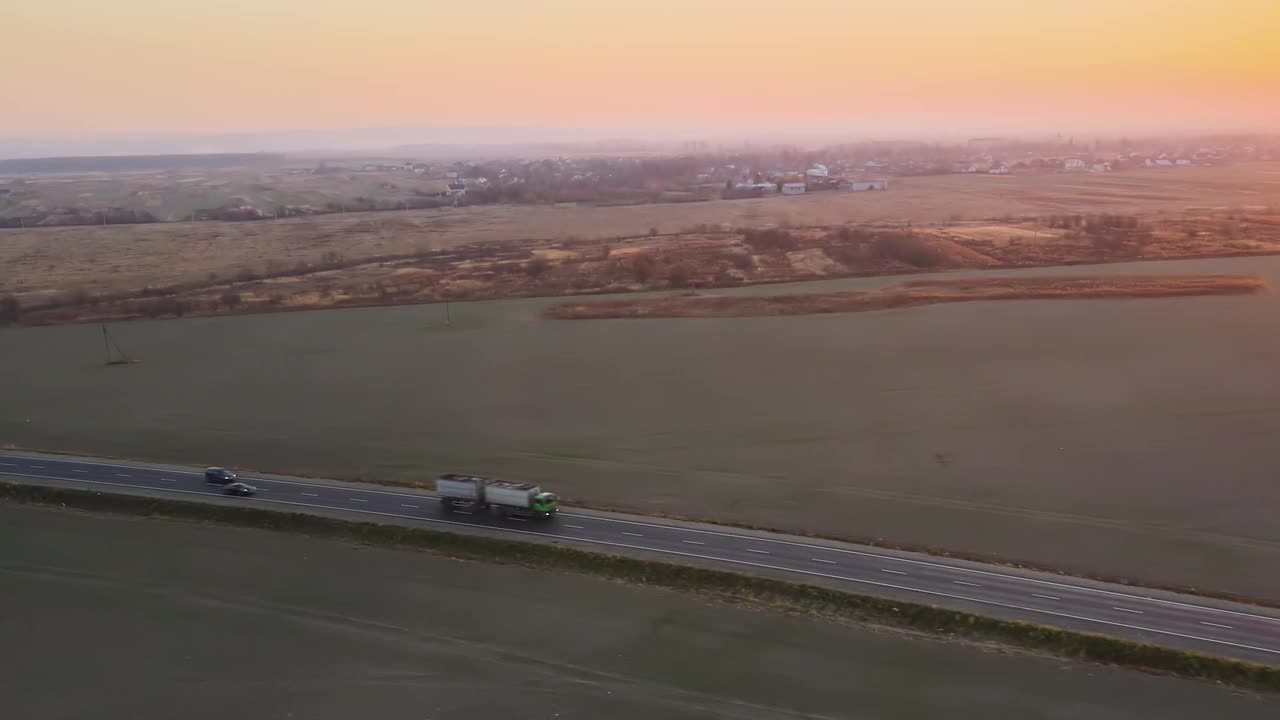 高空鸟瞰图半卡车与货运拖车驾驶在公路上拖货物在晚上。交付、运输和物流概念视频素材