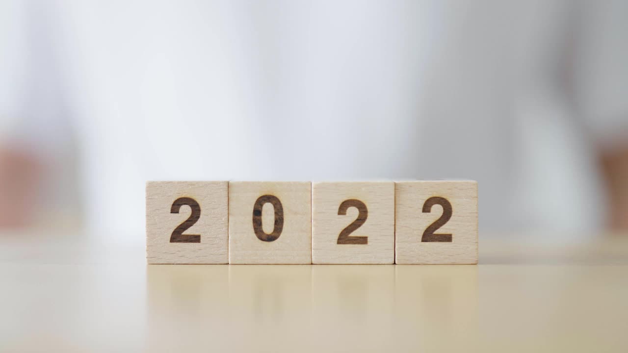 2022年新年改为2023年。用手翻转木制方块。新年决心，圣诞快乐视频素材