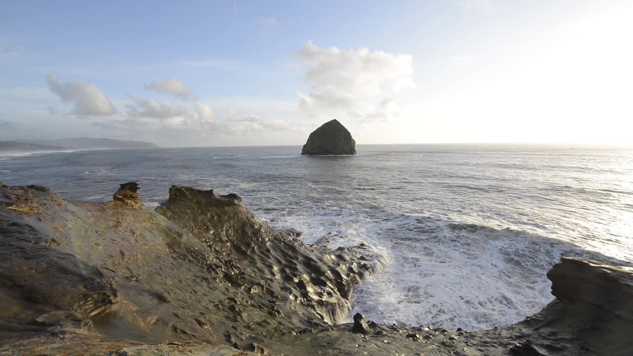 海浪拍打着岩石，映衬着海滩上的天空视频素材