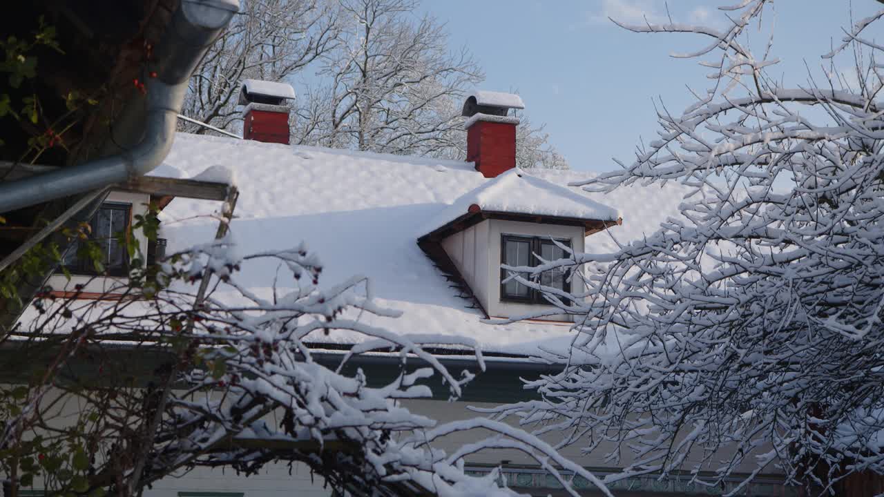 积雪覆盖的屋顶，冬天有天窗和烟囱视频素材