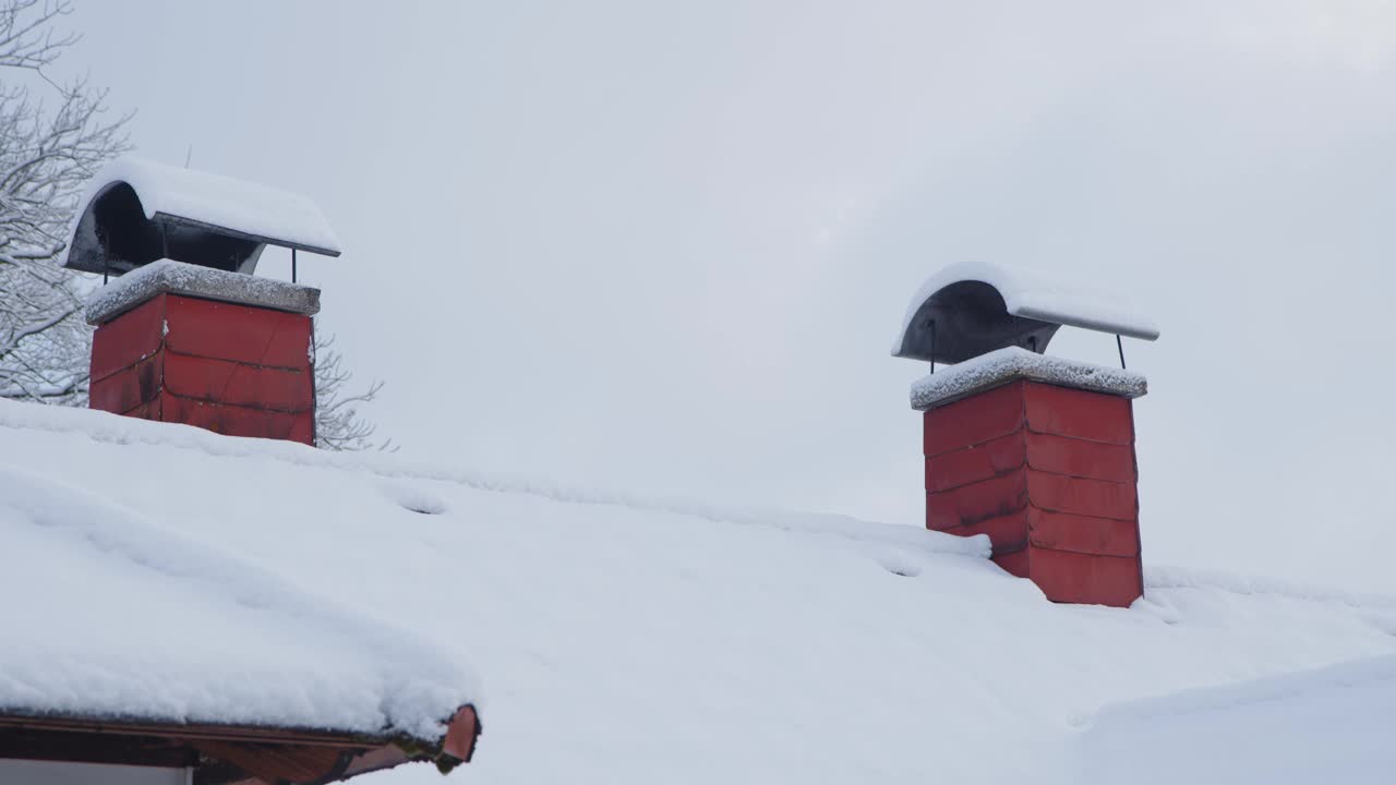 积雪覆盖的屋顶，冬天有天窗和烟囱视频素材