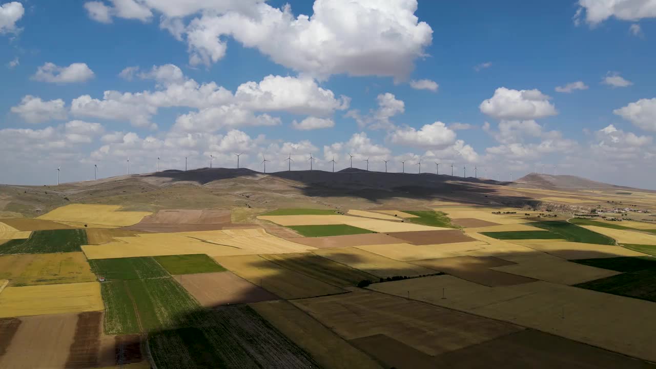 在土耳其明亮的天空下，用风力涡轮机俯瞰山上的草地和田野视频素材