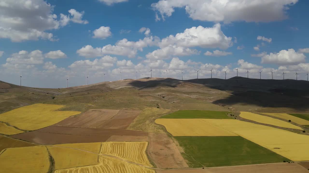 在土耳其明亮的天空下，用风力涡轮机俯瞰山上的草地和田野视频素材