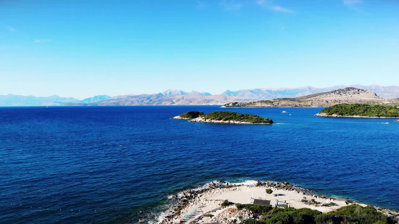 飞越蓝色风景海边离子海边与岛屿，旅游假期空中拍摄，蓝色的水，阳光灿烂的日子，阿尔巴尼亚克萨米尔视频素材