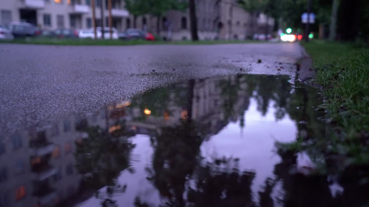 夜晚雨水落在城市的水坑里视频素材