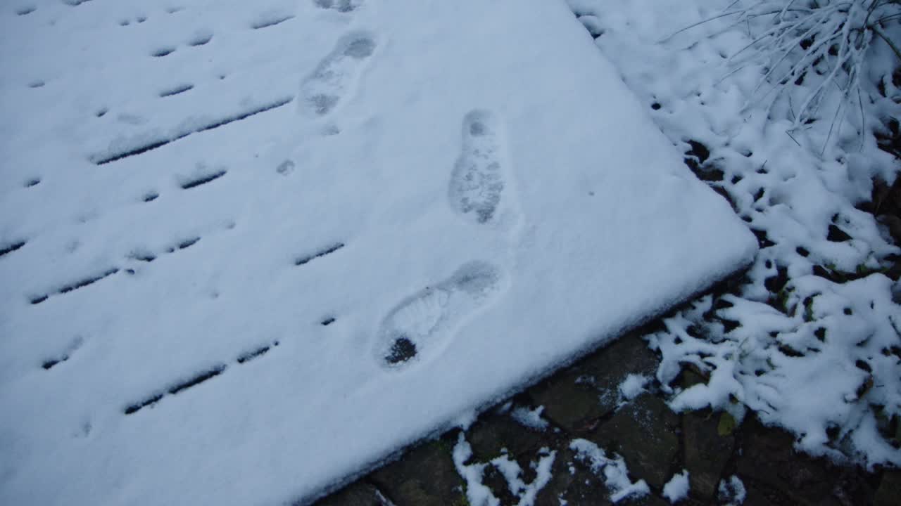 积雪覆盖的人行道上有人类脚印视频素材