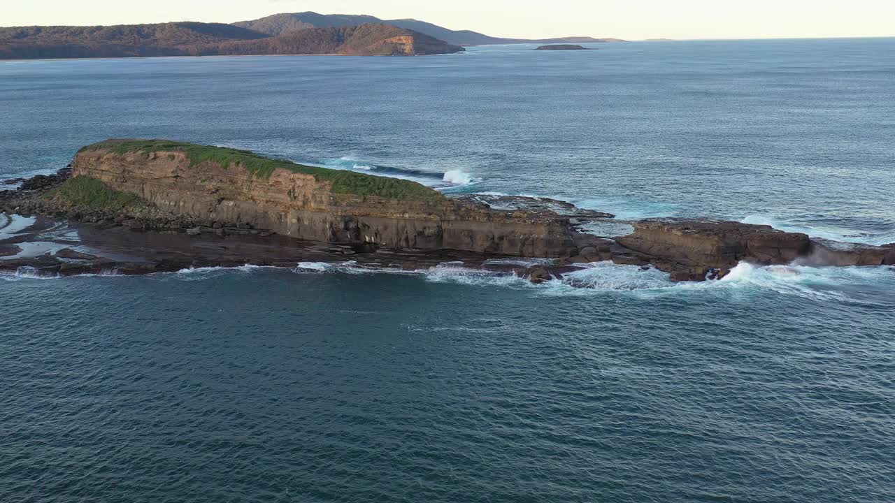 广阔的海岸岛屿与波浪打破金色的光视频素材