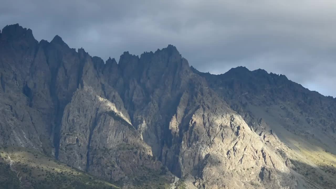 在日出时，云在岩石山上移动的时间延迟视频素材