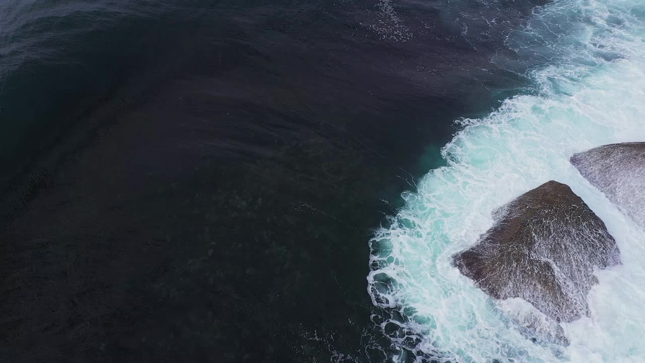 航拍大风暴潮海浪打破接近岩石与戏剧性的照明视频素材