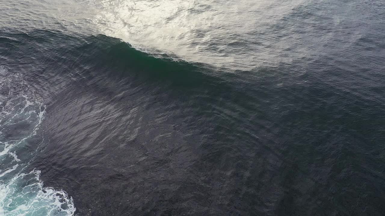 鸟瞰图的大海浪打破接近岩石与清晨金色的光视频素材