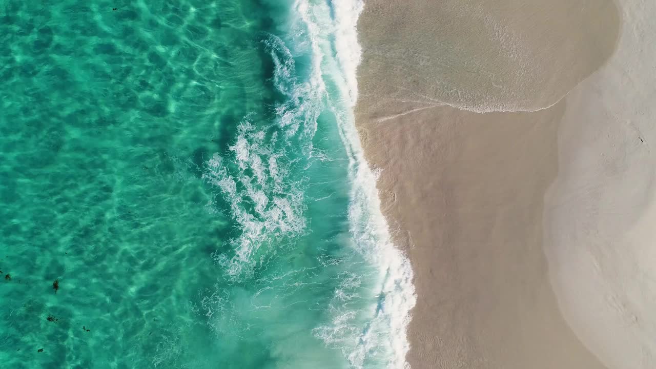 在一片僻静的白色沙滩上，漂浮在海浪之上视频素材