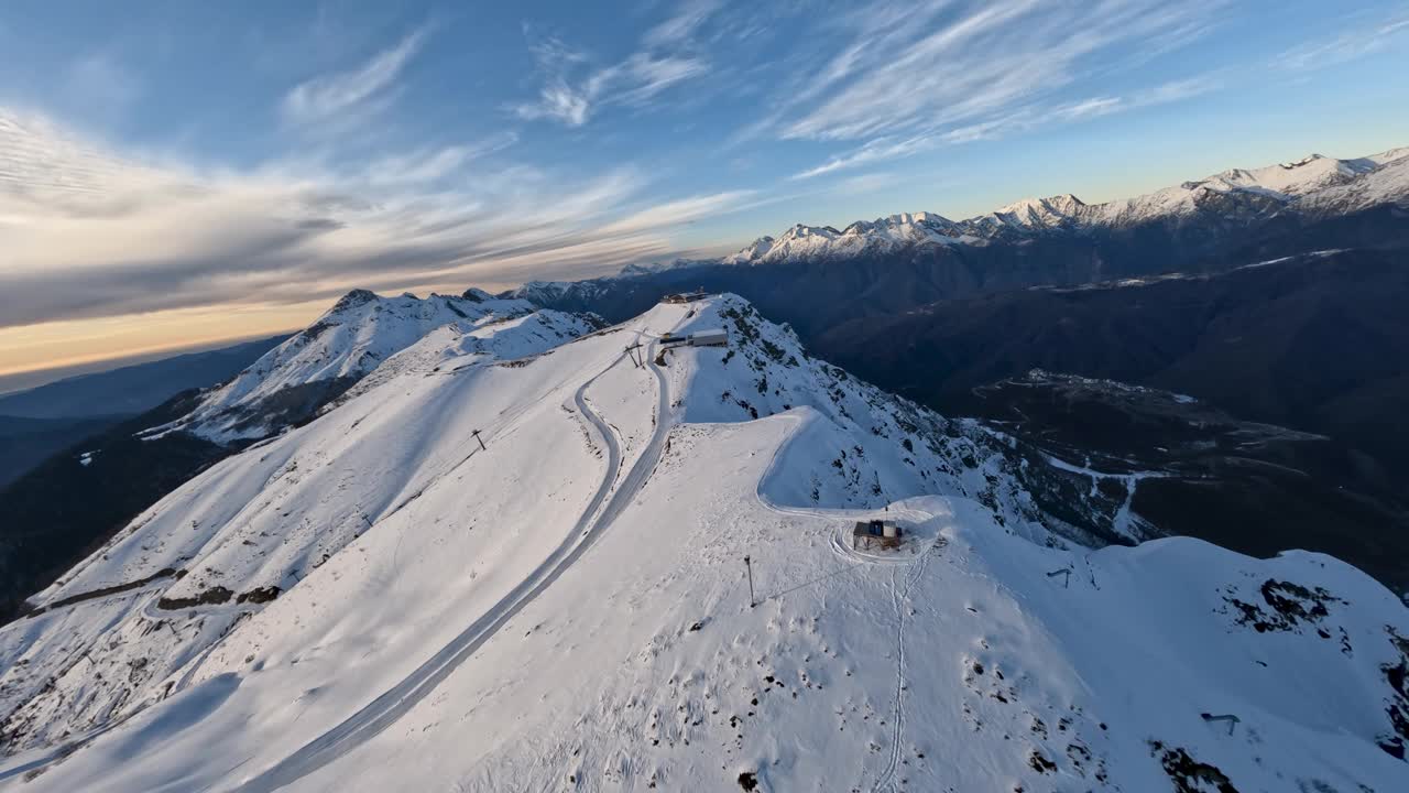 日落时分鸟瞰雪山山顶滑雪场基础设施索道工业建设视频素材