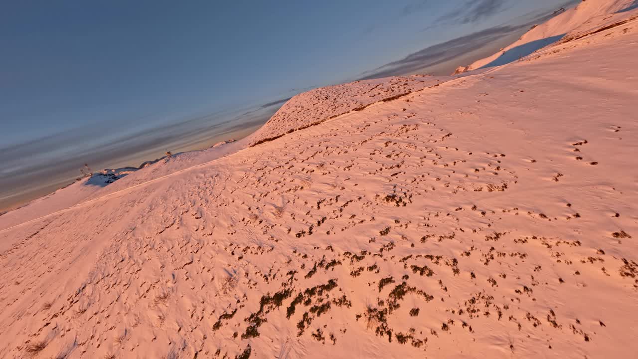 滑雪场房屋建筑在雪山山顶环绕日落，日出，阳光，光线鸟瞰视频素材