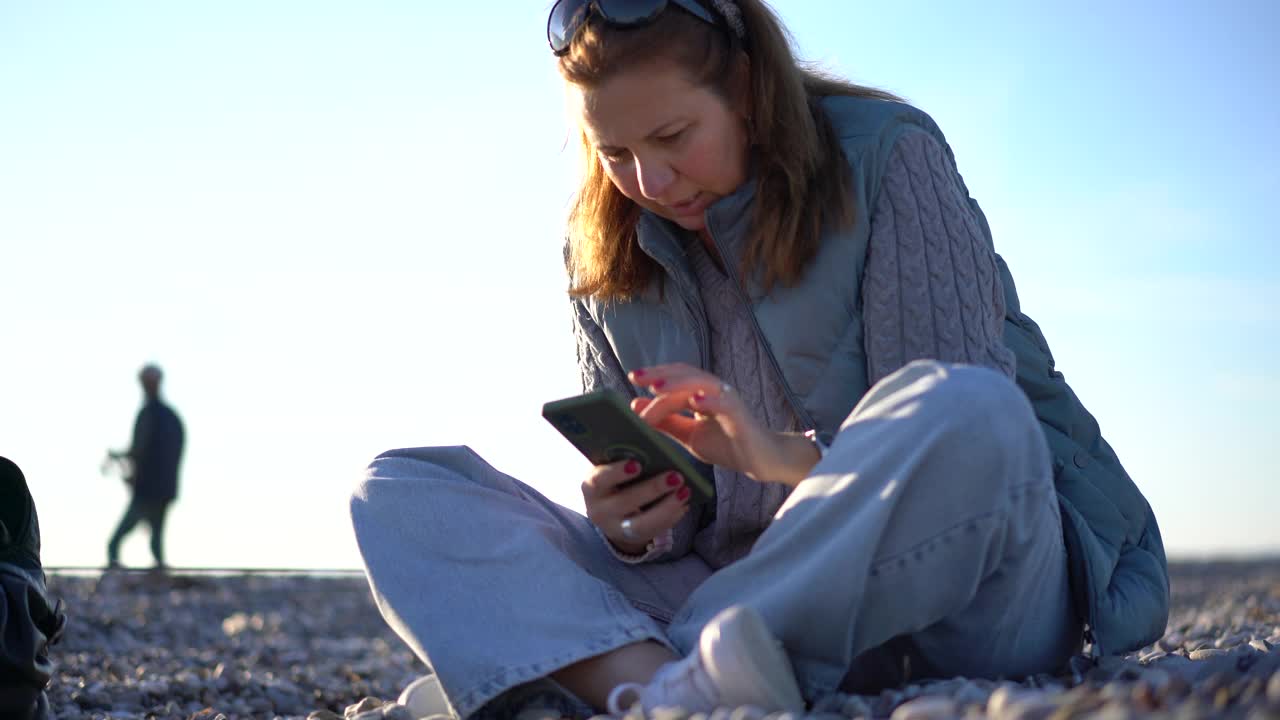 成熟美丽的白人女子在海滩上使用电话。视频素材