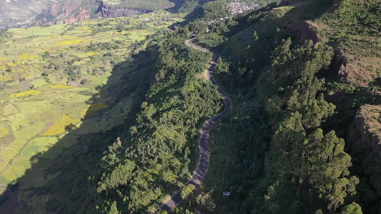 山坡上有高速公路的绿色田野的空中景观视频素材