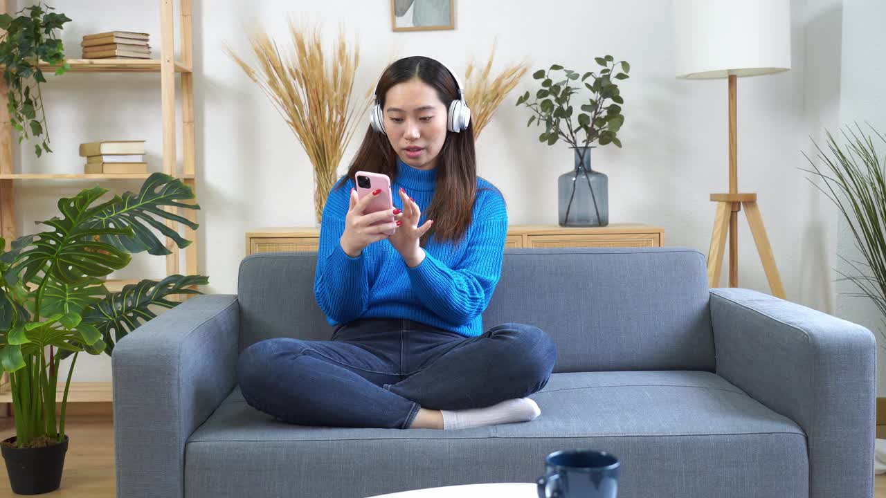 微笑的女人用智能手机听音乐视频素材