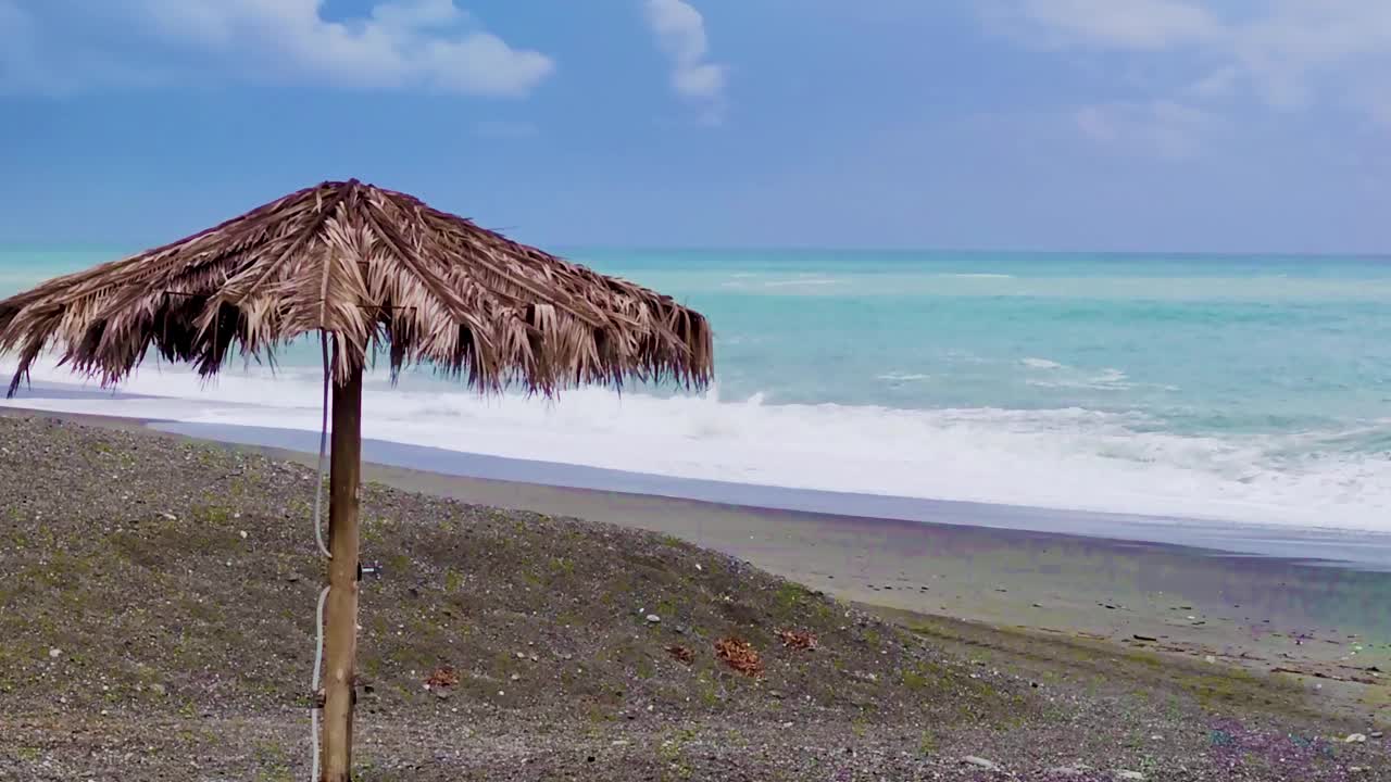 热带海滩上棕榈伞的电影美景。一个浪漫度假或水疗周末度假的好地方。空旷的天堂海滩俯瞰绿松石海视频素材