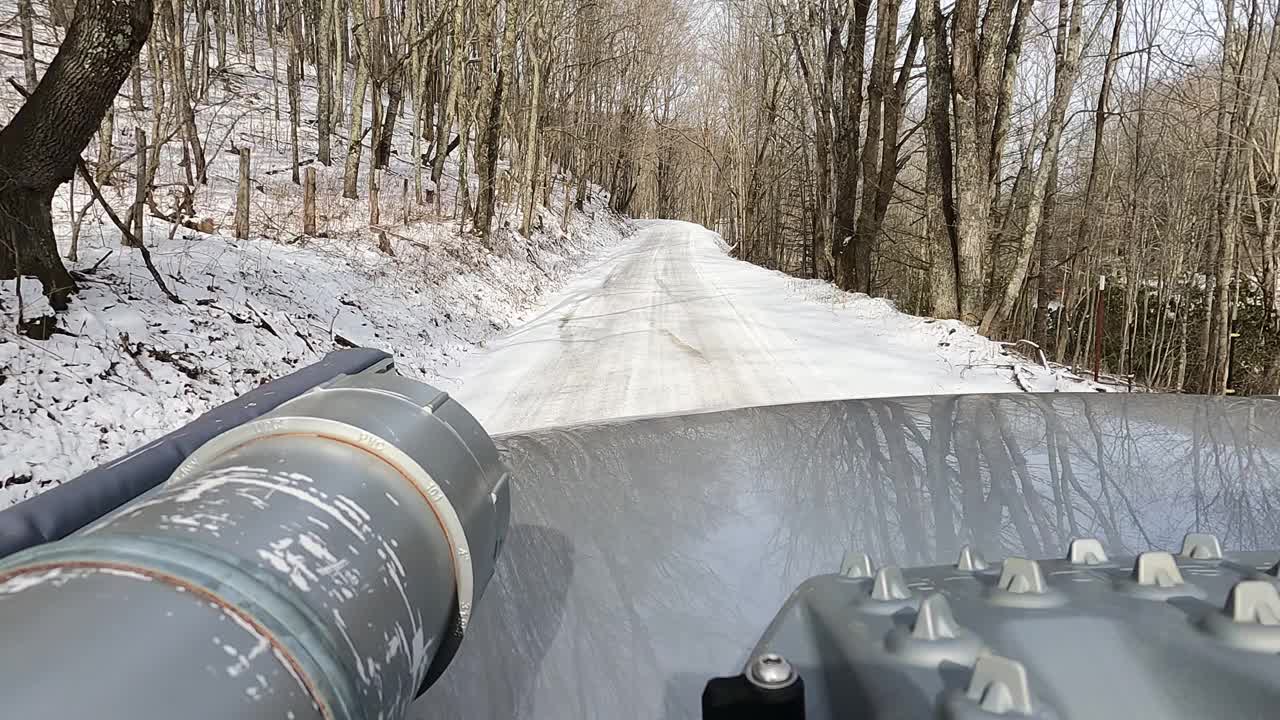 车顶架的观点，在国家森林与雪的土路上驾驶的越野车视频素材