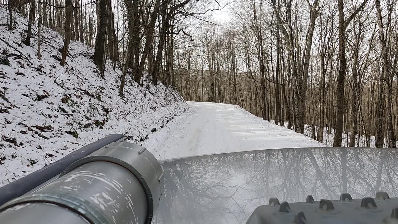 车顶架的观点，在国家森林与雪的土路上驾驶的越野车视频素材