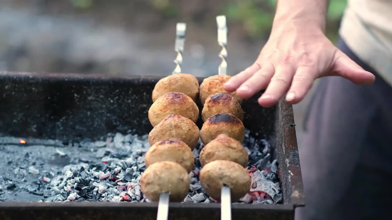 烤蘑菇串在烤架上。在夏天做美味的素食烧烤视频素材