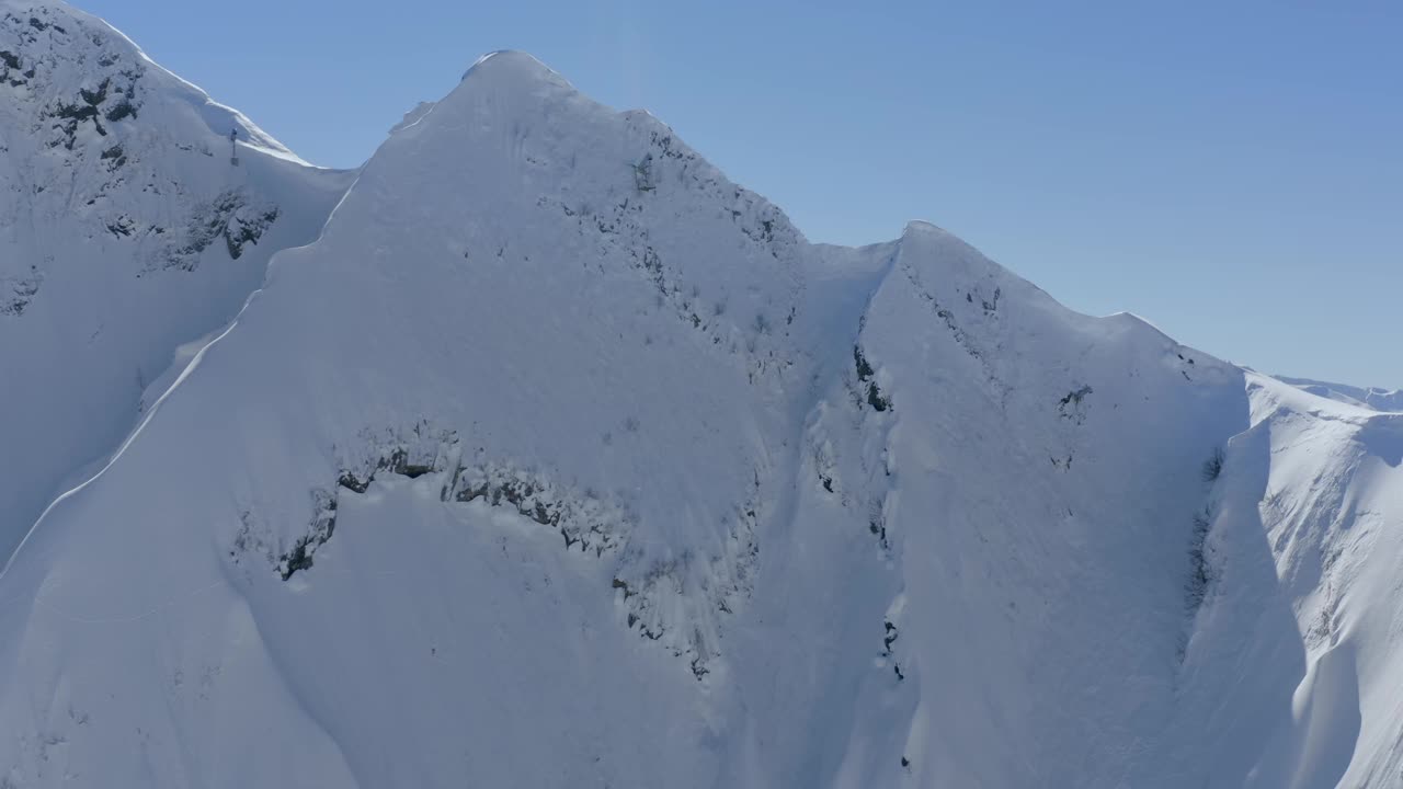 阳光明媚的高山山谷滑雪场风景如画的高山山顶霜冻冬季环境鸟瞰视频素材