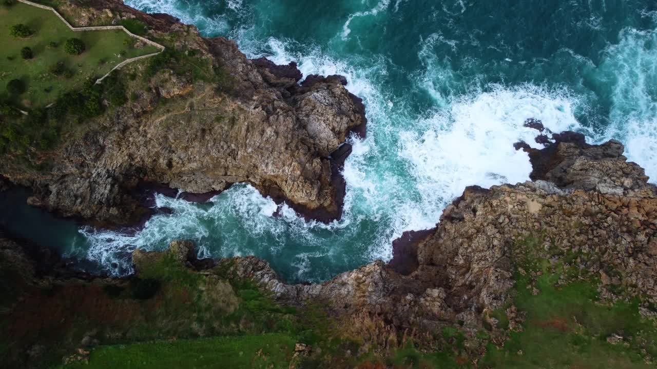 海浪拍打岩石背景的鸟瞰图。高质量4k镜头视频素材