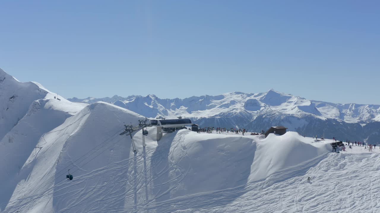 山顶有索道，滑雪场有游客，人们积极爱好休闲活动，鸟瞰视频素材