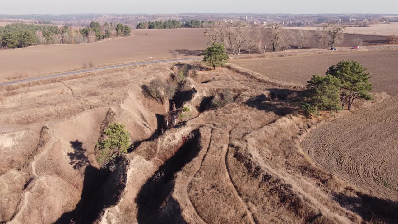 陡峭的沟壑之间的农业土地旁边的道路，鸟瞰图视频素材