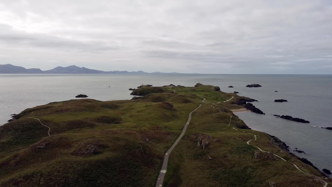 鸟瞰图Ynys Llanddwyn岛安格尔西岛海岸步道与斯诺登尼亚山脉横跨爱尔兰海拉回来视频素材