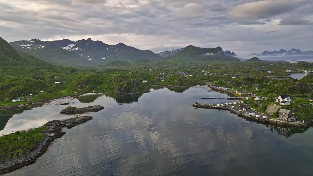 Ørsvågvær Norway v3 low flyover water inlet capturing waterfront campsite surrounded by breathtaking mountainscape and sunset sky reflecting on water surface - Shot with Mavic 3 Cine - June 2022视频素材