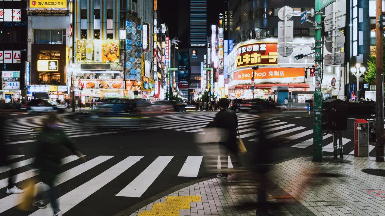 东京新宿歌舞伎町哥斯拉街的日本人、亚洲旅行者穿越马路、汽车交通运输的夜间城市景观。亚洲旅游旅游或日本交通视频素材