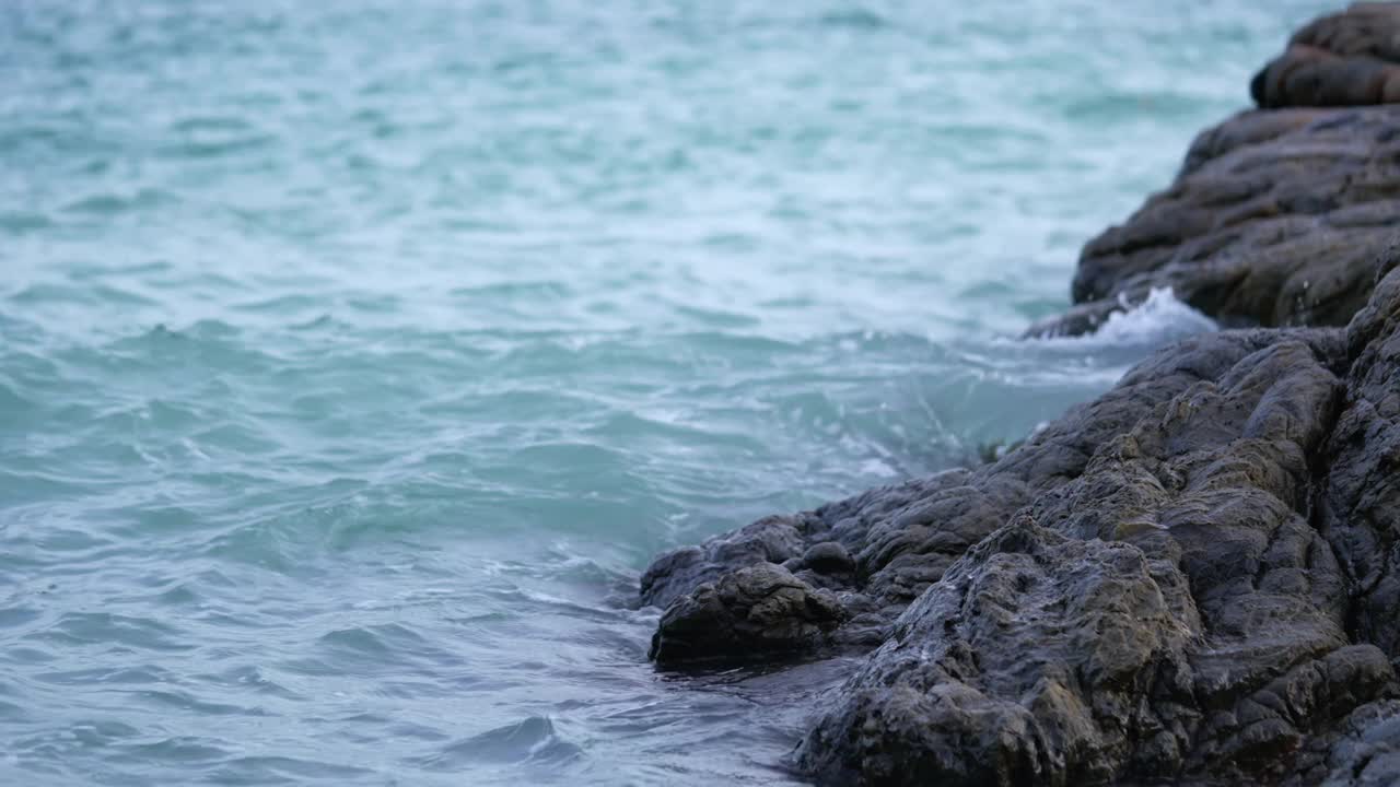 海浪拍打着海滩上的岩石。视频素材