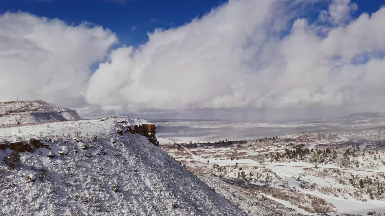 飞越冰雪覆盖的冬季山地景观与道路在科罗拉多地区视频素材