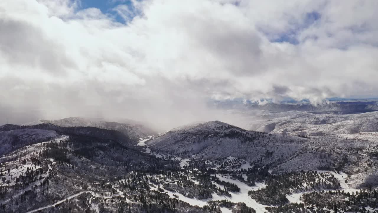 在科罗拉多州暴风雪期间，飞越冰雪覆盖的冬季山地景观和森林视频素材