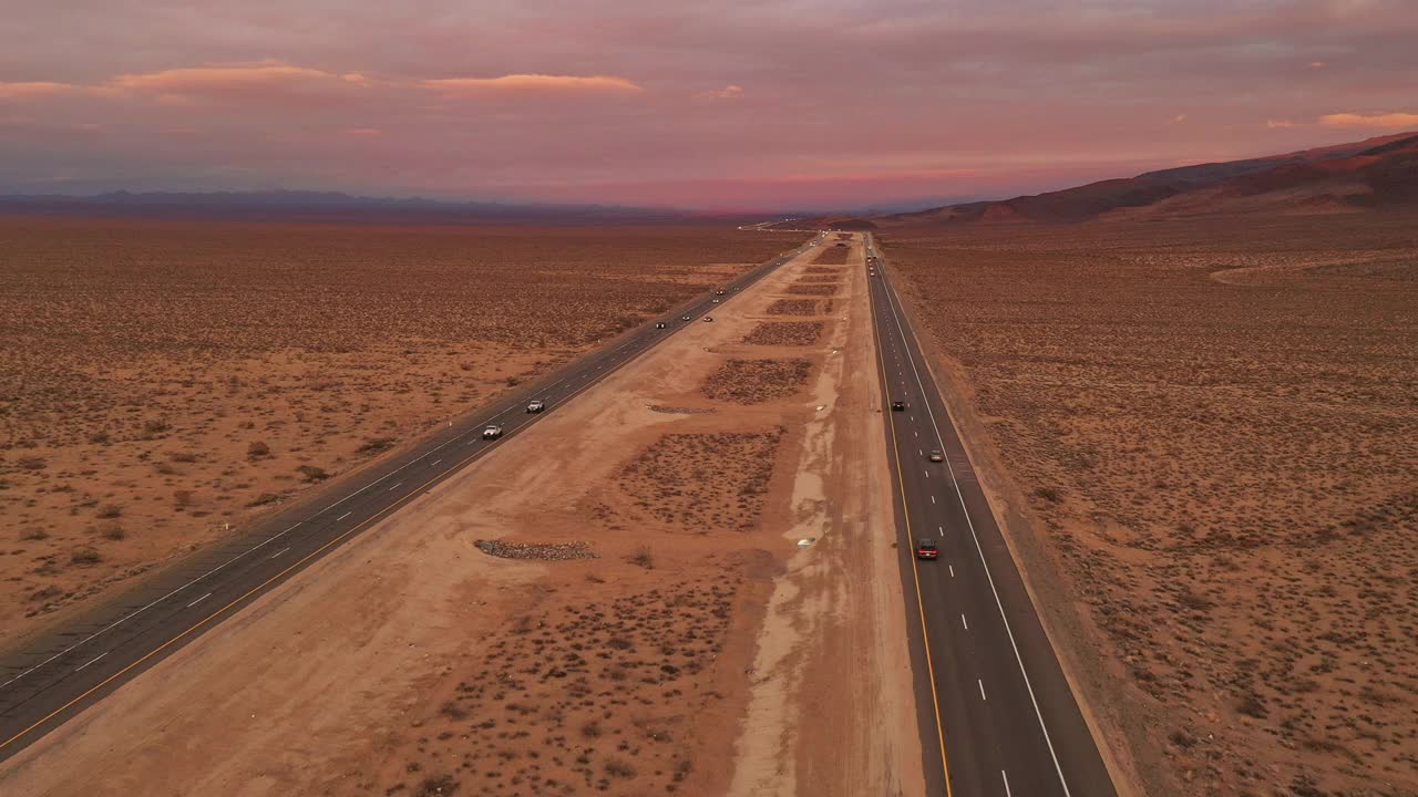 繁忙的高速公路上，汽车和卡车在日落时分沿着笔直的沙漠公路行驶视频素材