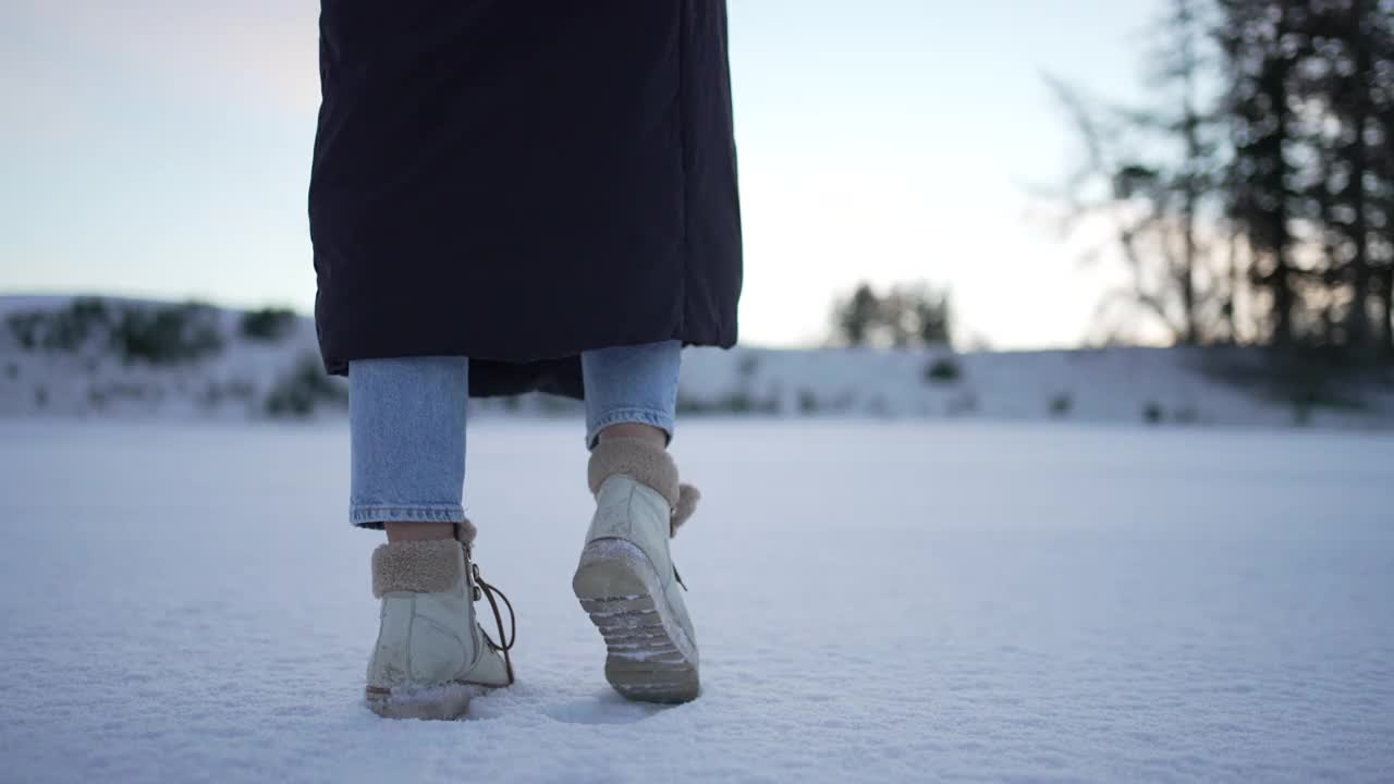 穿着冬衣的女子走在雪景上视频素材