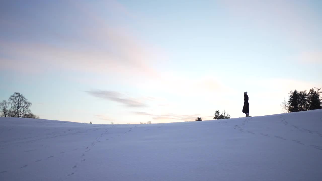 穿着冬衣的女子走在雪景上视频素材