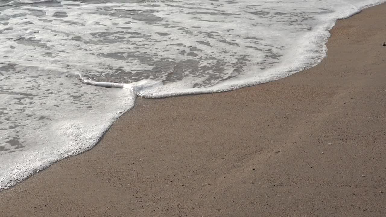 沙滩上的沙子伴随着海浪视频下载