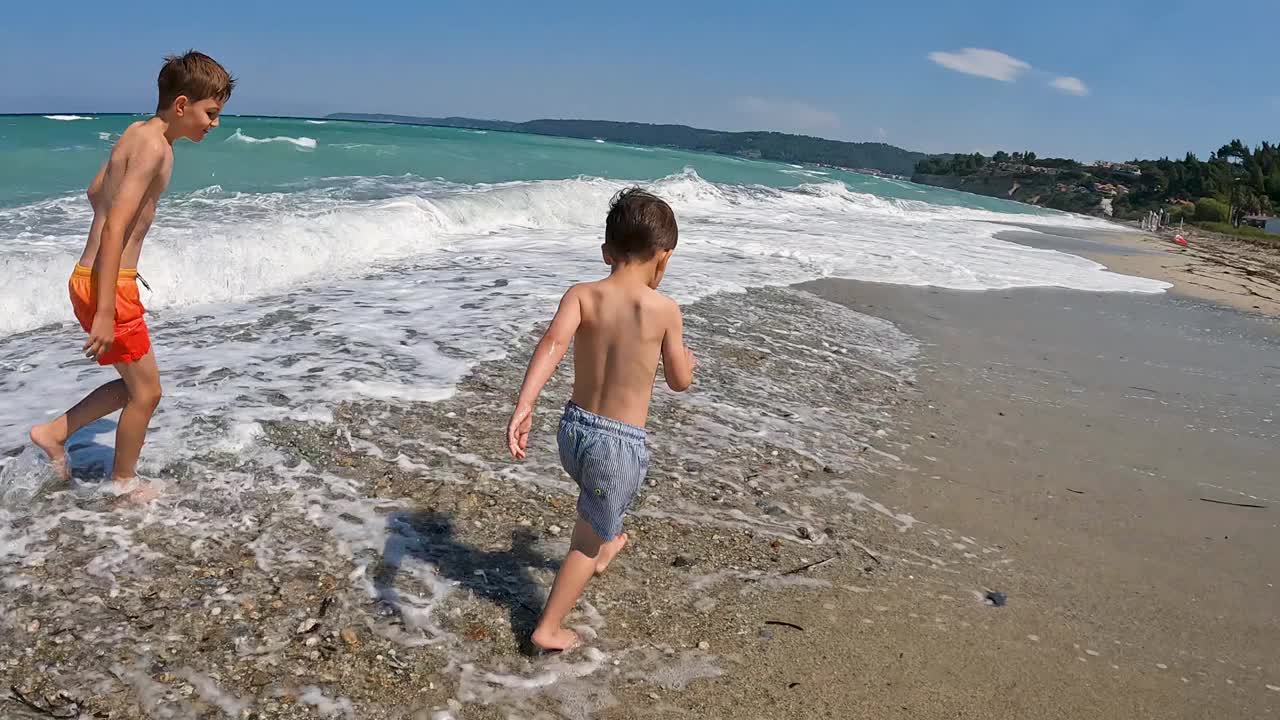 小男孩们在海滩上散步视频素材