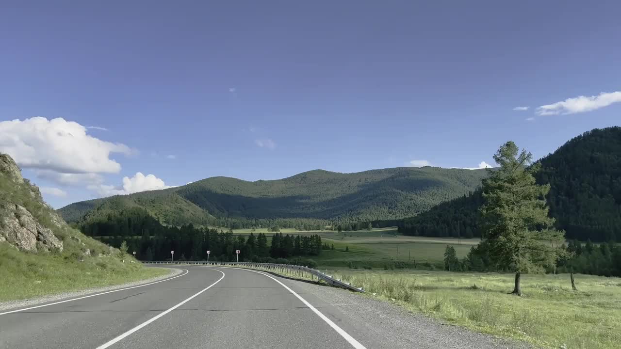 汽车在风景的背景下沿着山路行驶。视频素材