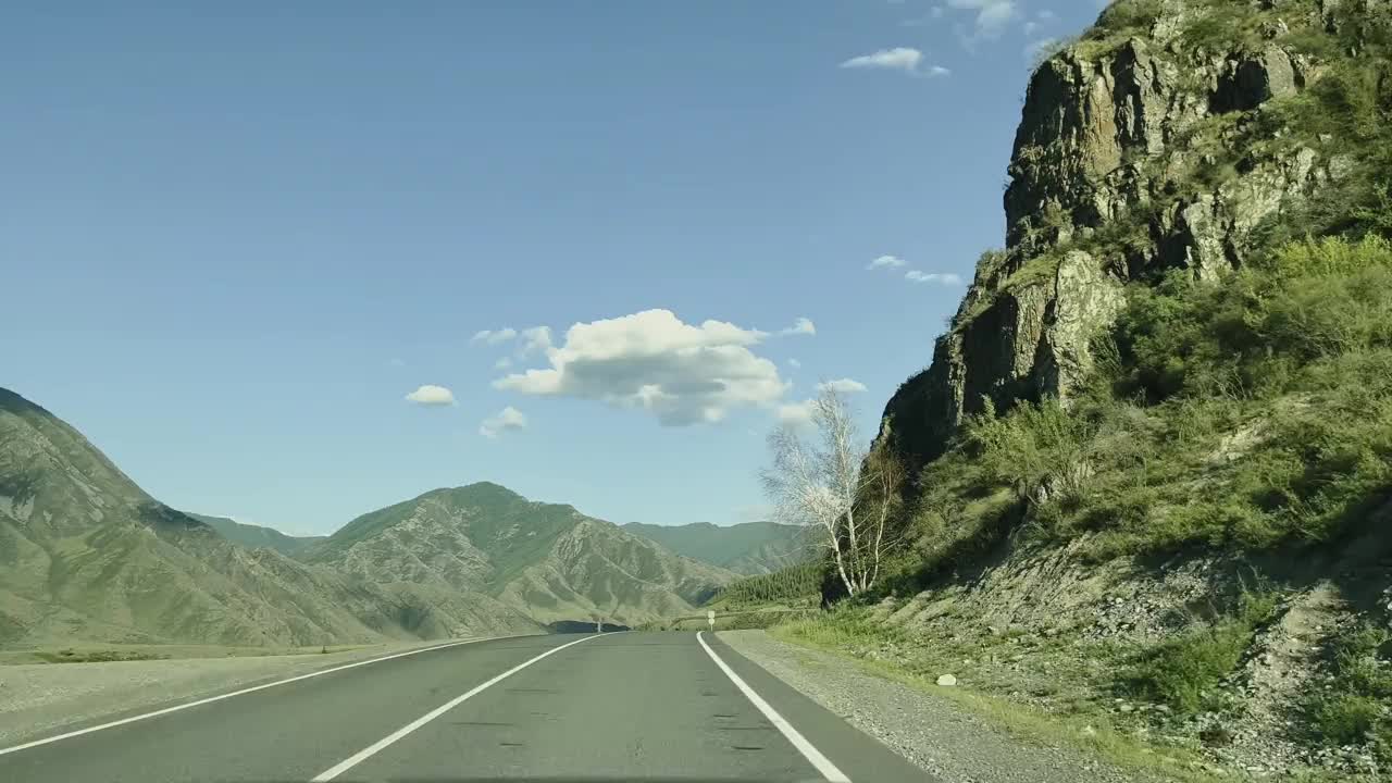 汽车在青山丛中沿着蜿蜒的山路行驶。视频素材