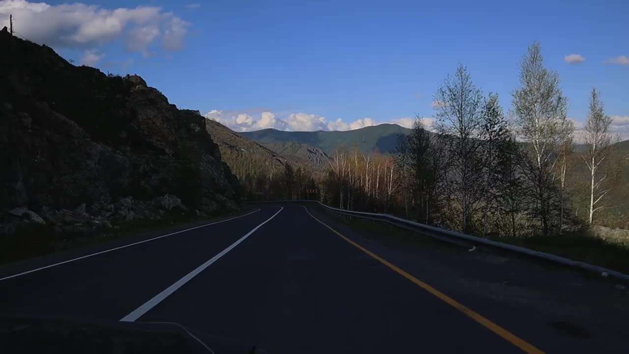 汽车沿着山脉蜿蜒而行，风景优美。视频素材