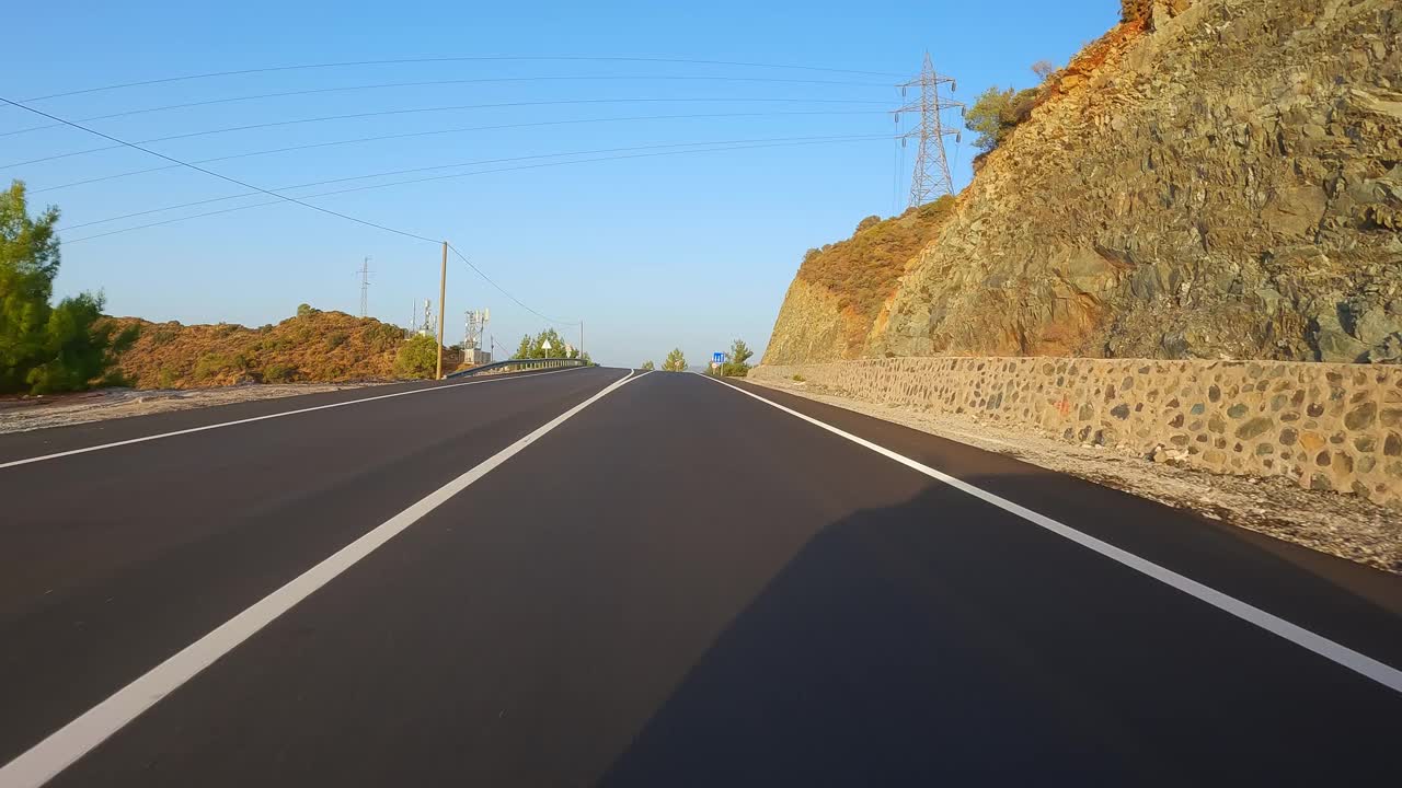 在有黑色沥青和新鲜白色斑纹的山路上行驶。开车旅行，第一人称视角。POV运输前进。视频素材