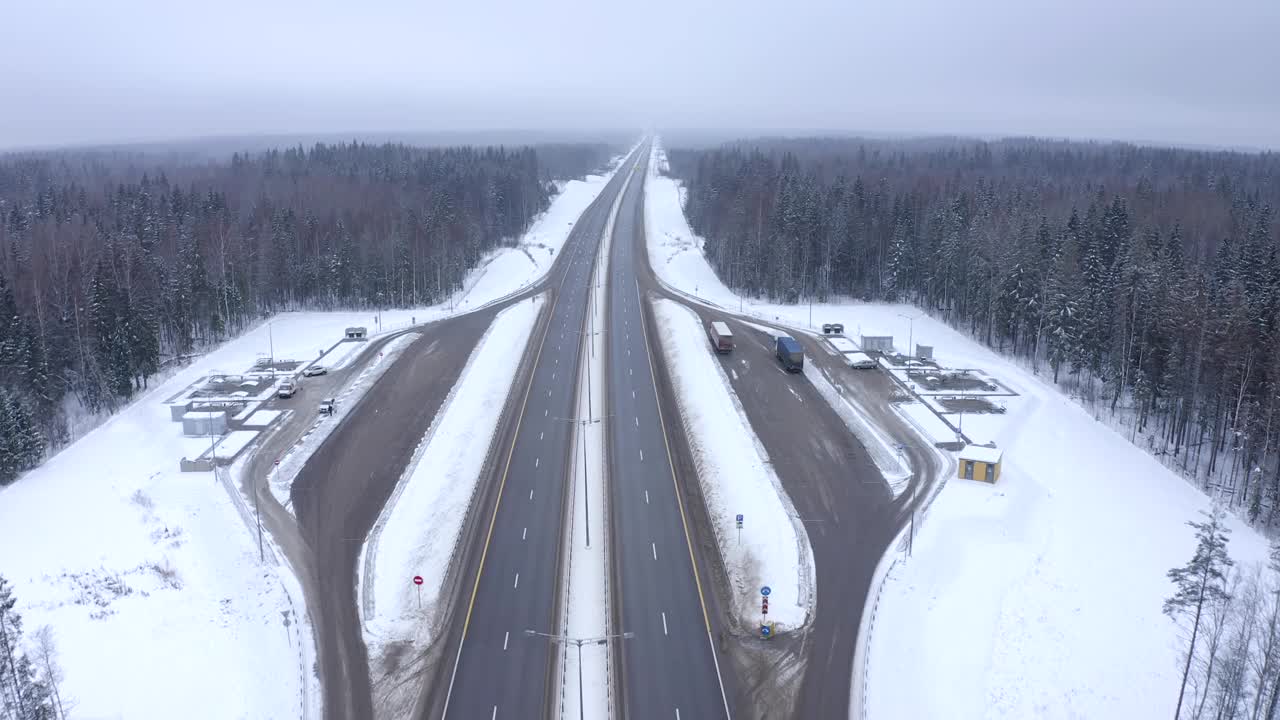 在一次自驾游中，一辆白色汽车在雪中穿过树林间的道路视频素材