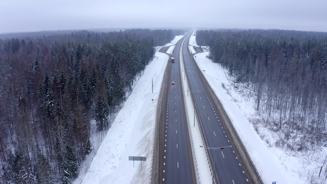 一辆白色汽车行驶在白雪覆盖的针叶林中。视频素材