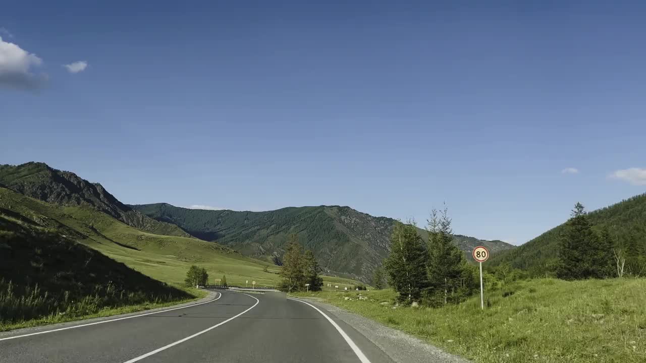 汽车在风景的背景下沿着山路行驶。视频素材