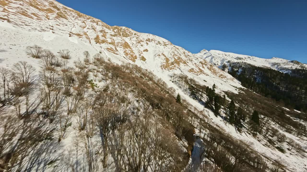 冬季雪山阳光明媚，山谷急速上升，峰顶覆岩，石质纹理视频素材