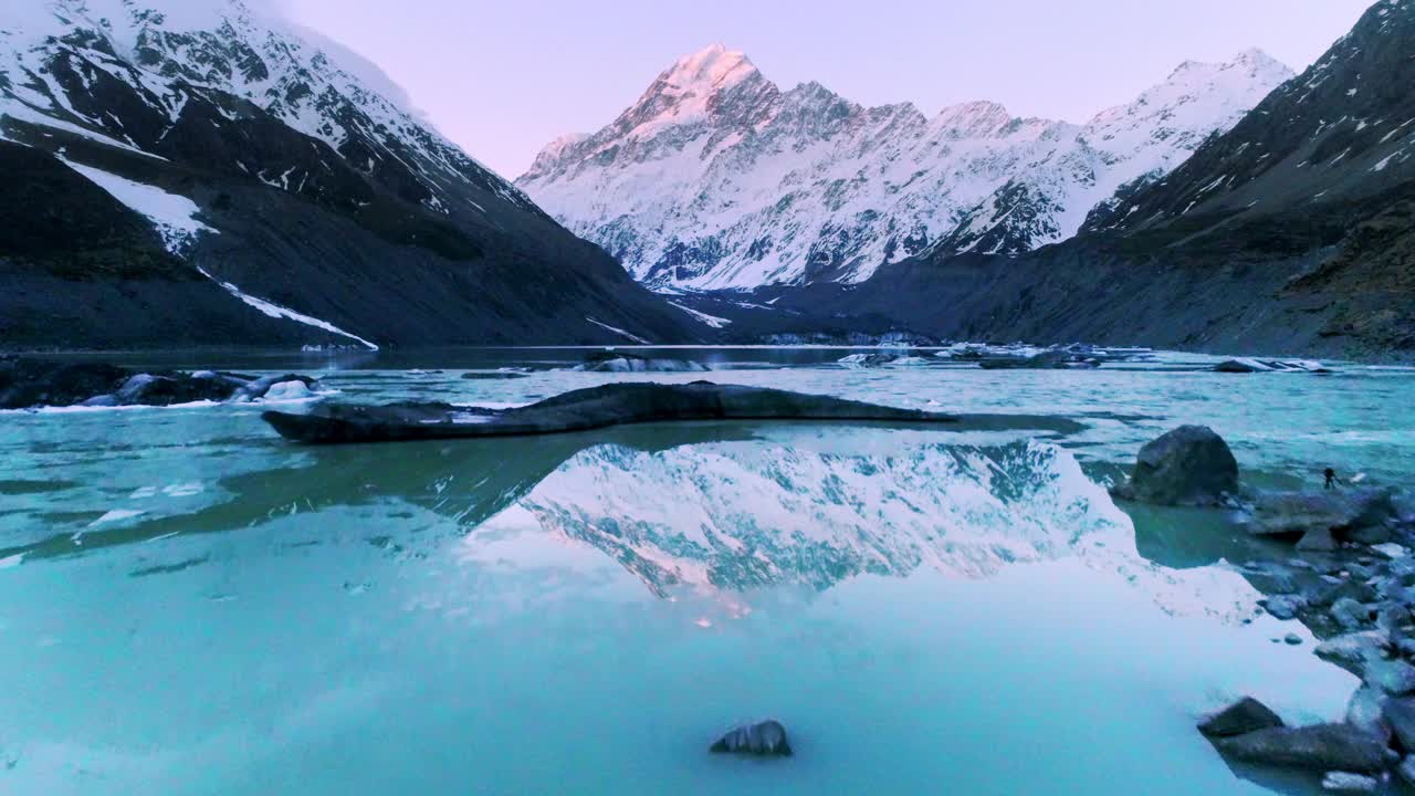 飞越冰湖，映照出壮丽的自然风光，雪山散发着金色的光芒视频素材